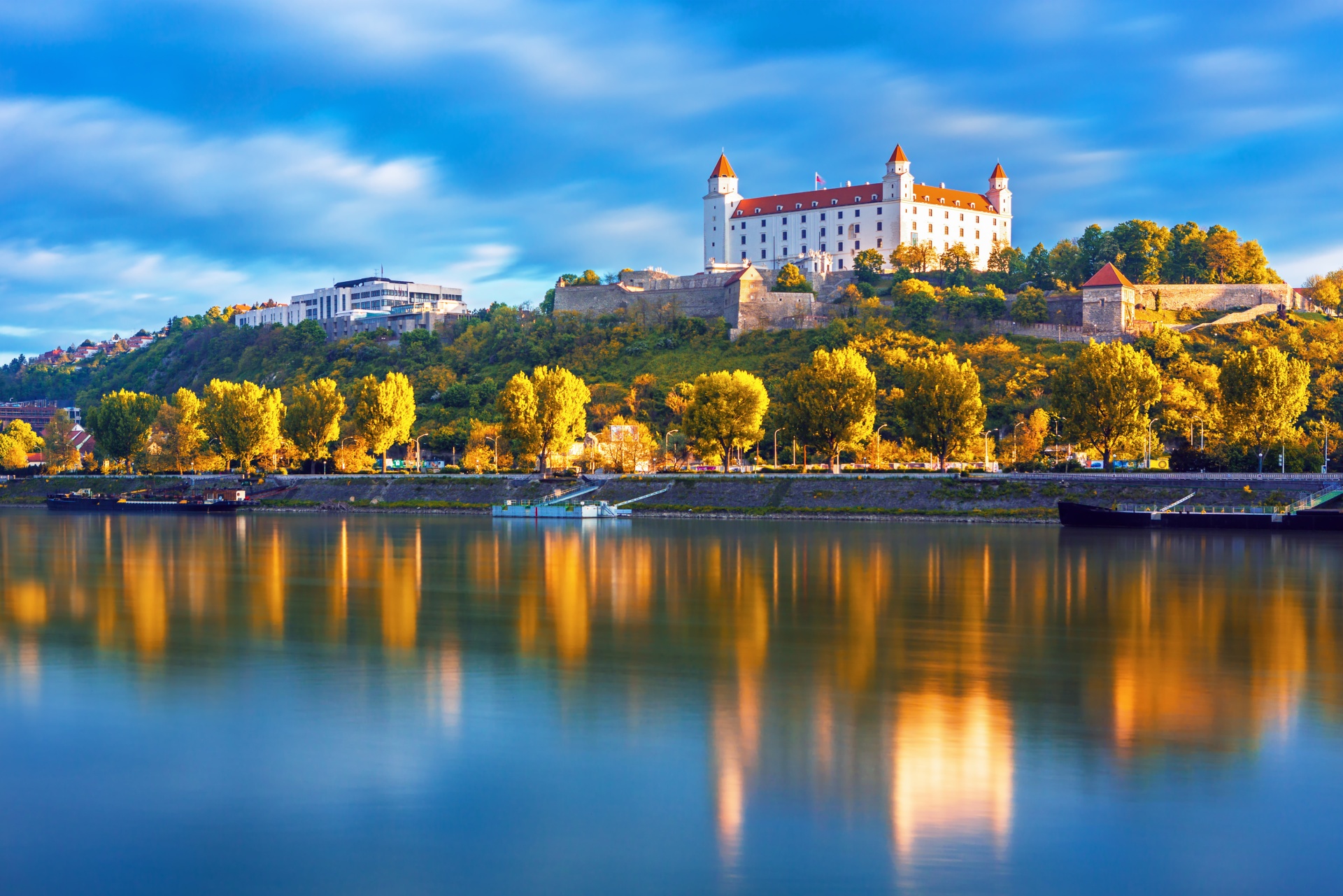 reka donava, ki teče skozi bratislavo, v jesenskih barvah, nad mestom se dviga bratislavski grad