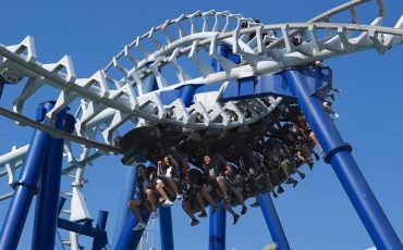 adrenalinska atrakcija v Gardalandu, modri stebri, bele tračnice in sedeži polni obiskovalcev