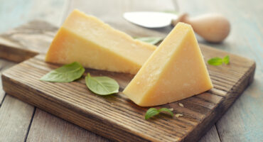 Parmesan,Cheese,On,Cutting,Board,With,Basil,And,Knife,On