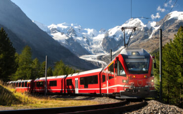rdeč vlak Bernina Express, v ozadju zasnežene gore