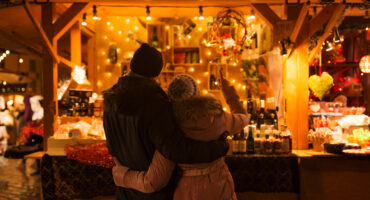 happy senior couple hugging at christmas market