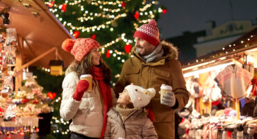 family with takeaway drinks at christmas market